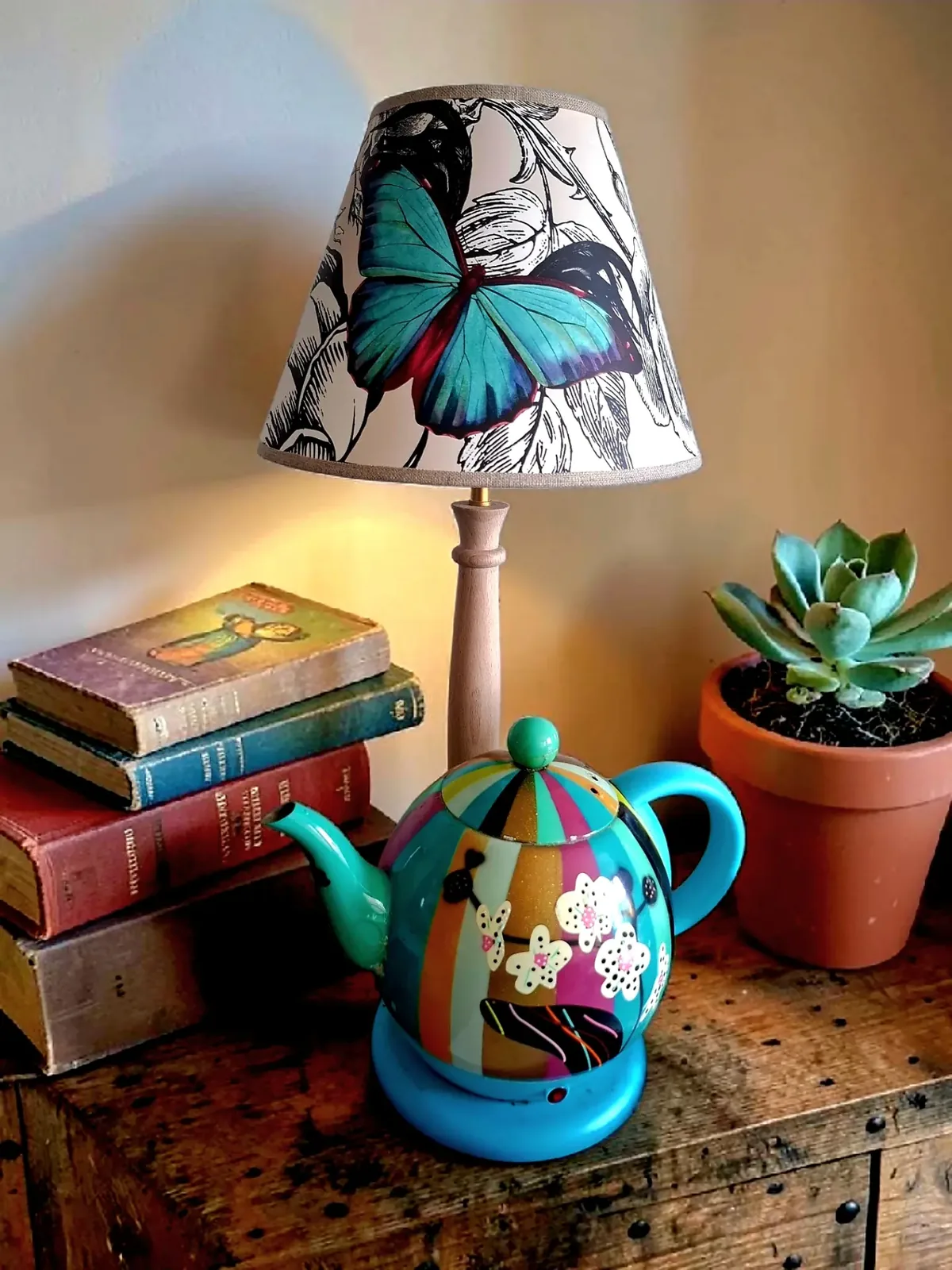 Abat-jour cône en papier peint à papillon turquoise sur un pied de lampe en bois assorti à une théière PYLONES