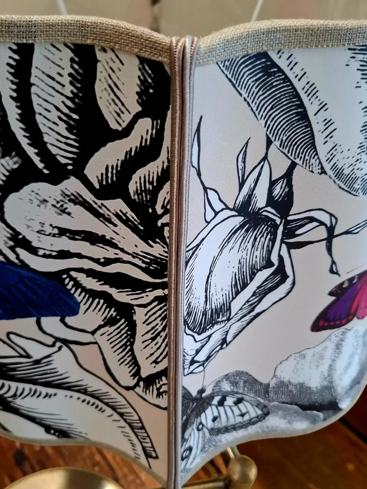 Gros plan sur un abat-jour en papier peint noir et blanc à papillon violet
