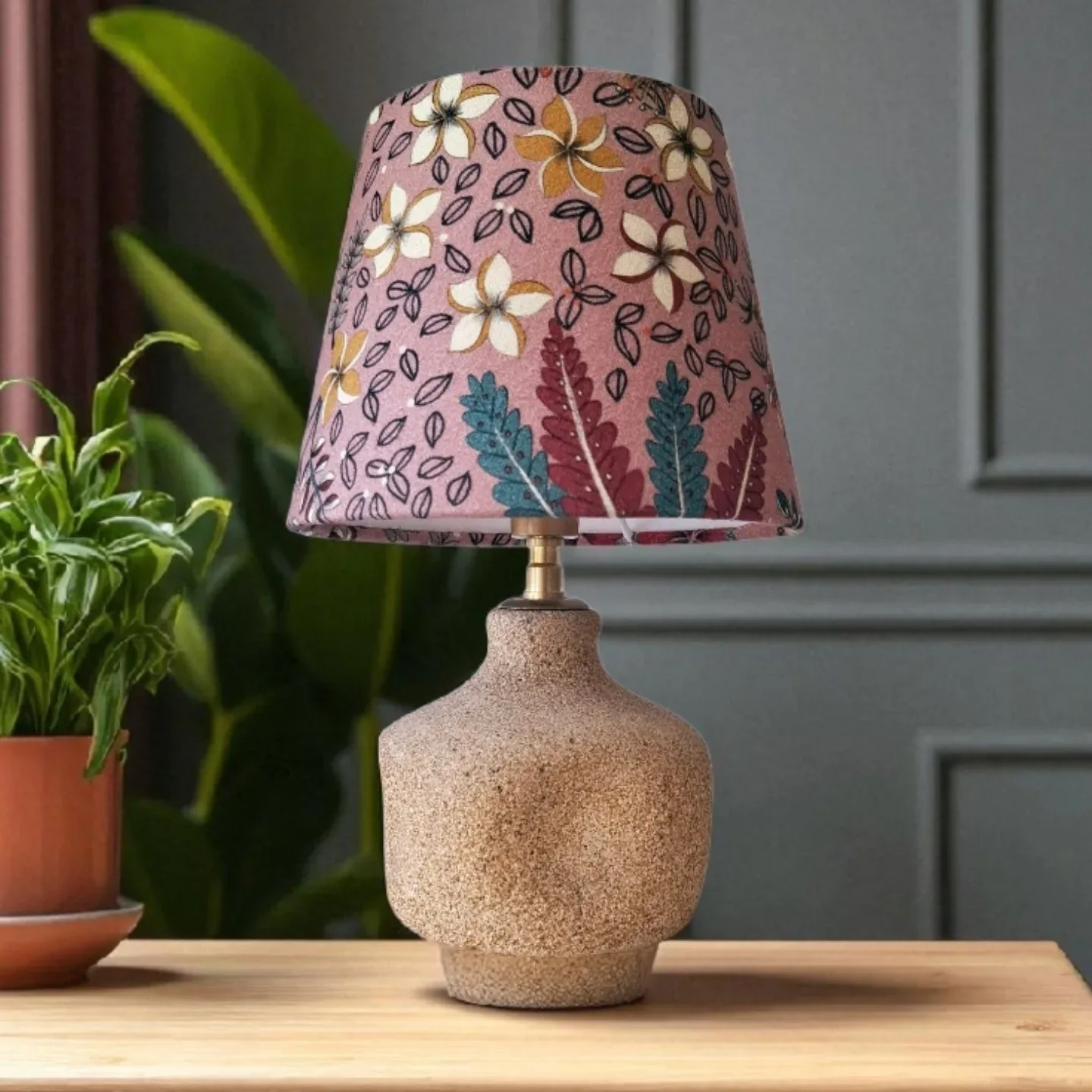 Lampe à pied en grès beige et abat-jour conique en tissu rose à fleurs stylisées