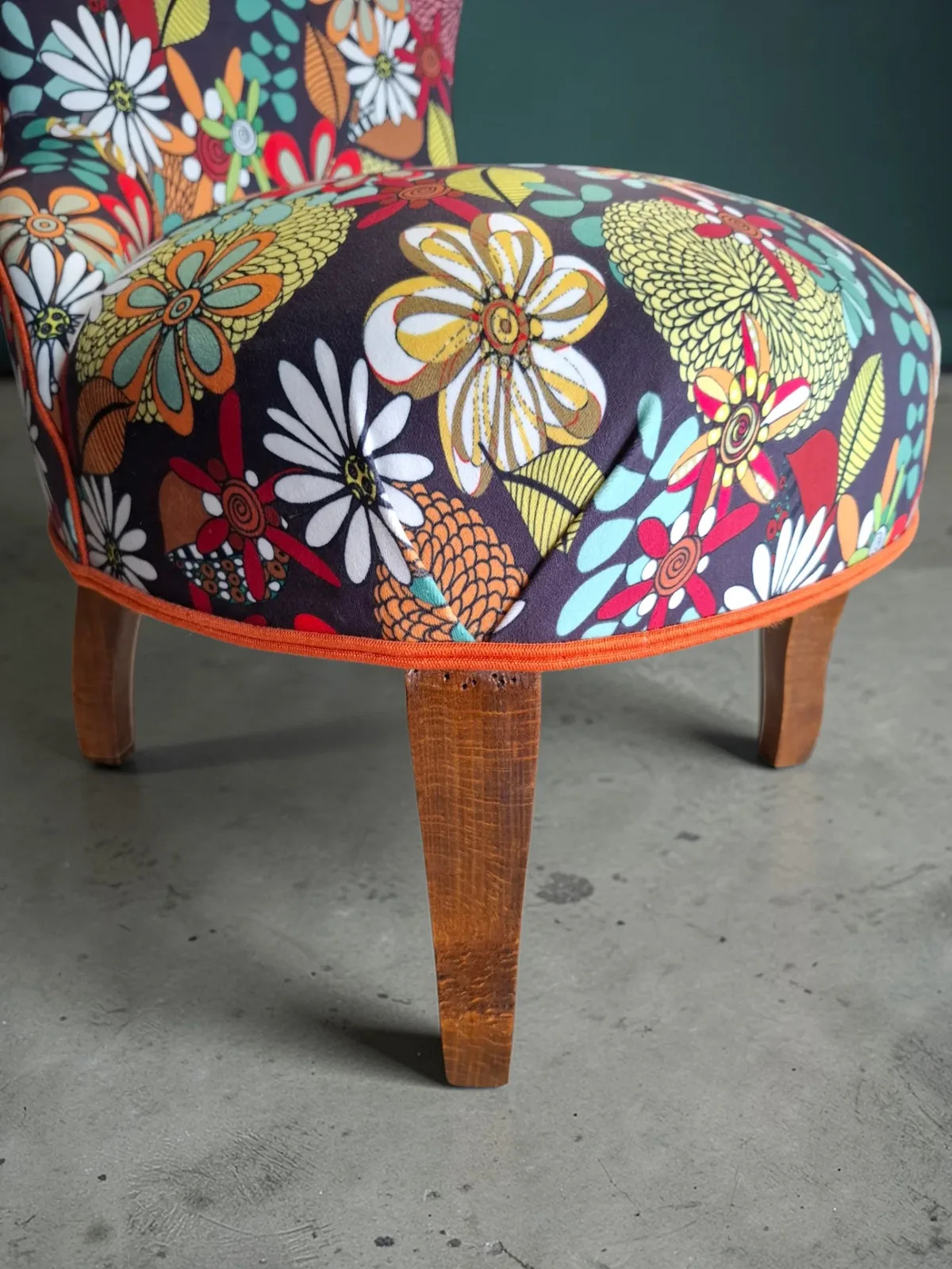 Détail de l'assise d'une chauffeuse fleurie Zéphyr & Co bordée d'un passepoil orange