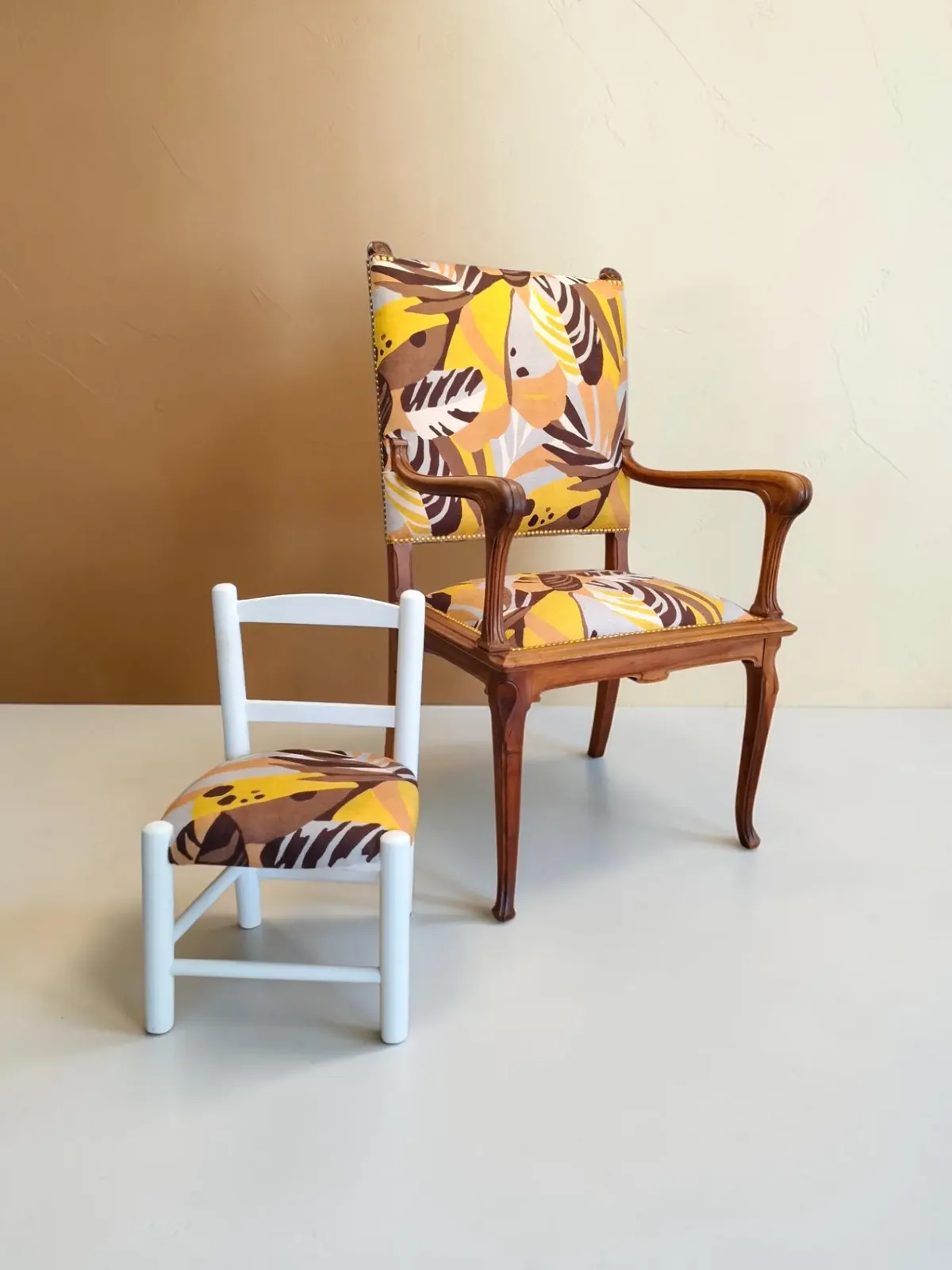 Fauteuil Art nouveau et petite chaise d'enfant blanche retapissés du même tissu jaune, brun et gris
