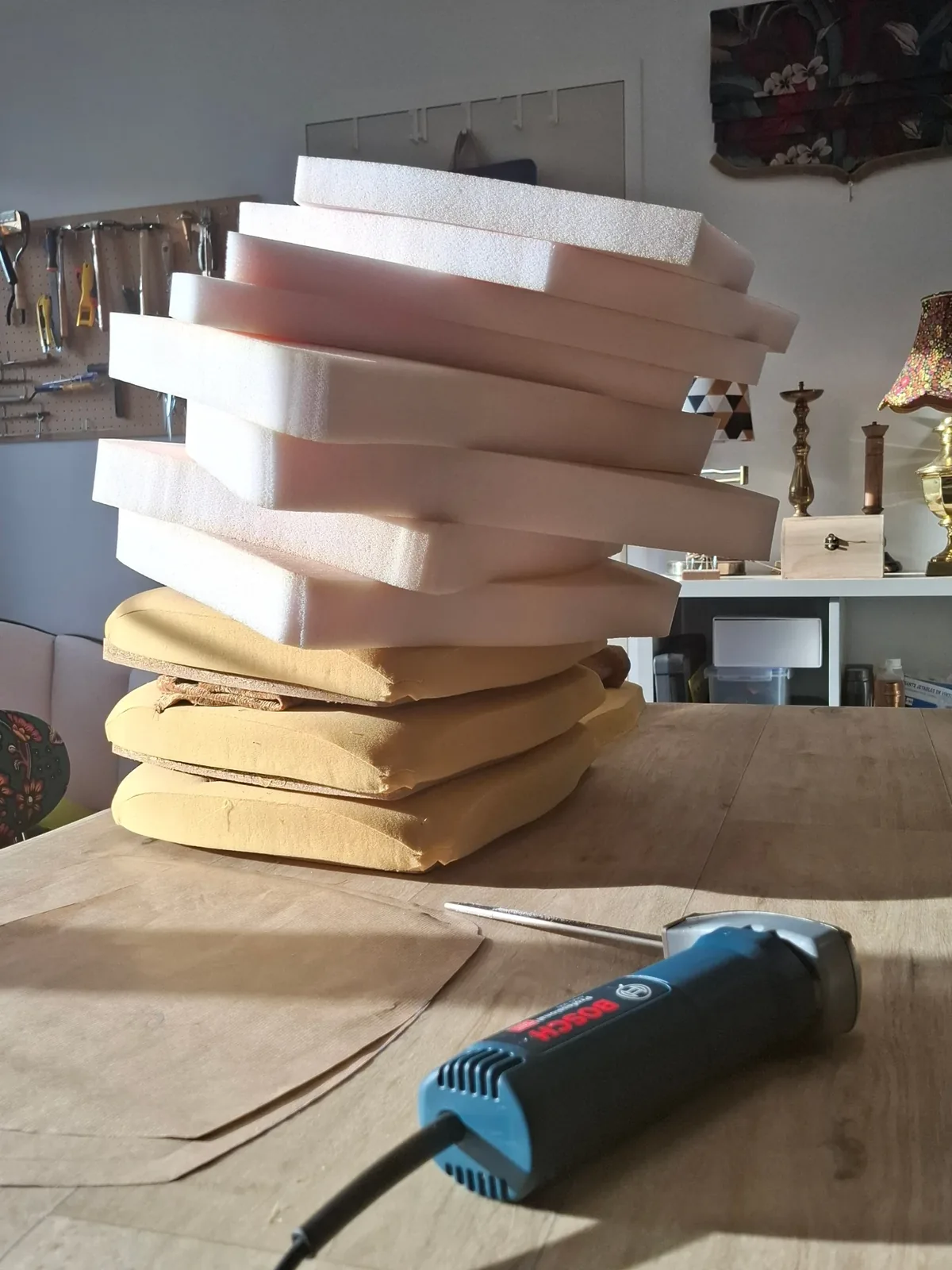 Pile de mousses Bultex découpées à la scie sur l'établi de l'atelier