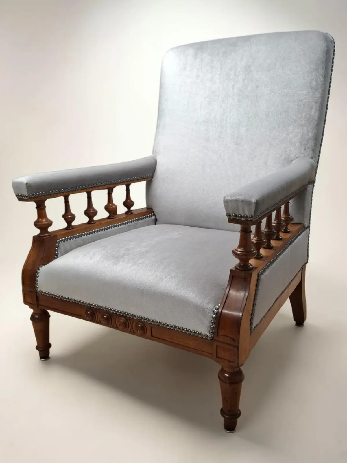 Fauteuil ancien à accoudoirs tournés retapissé en velours gris Olympe de Casal, clous noirs mouchetés