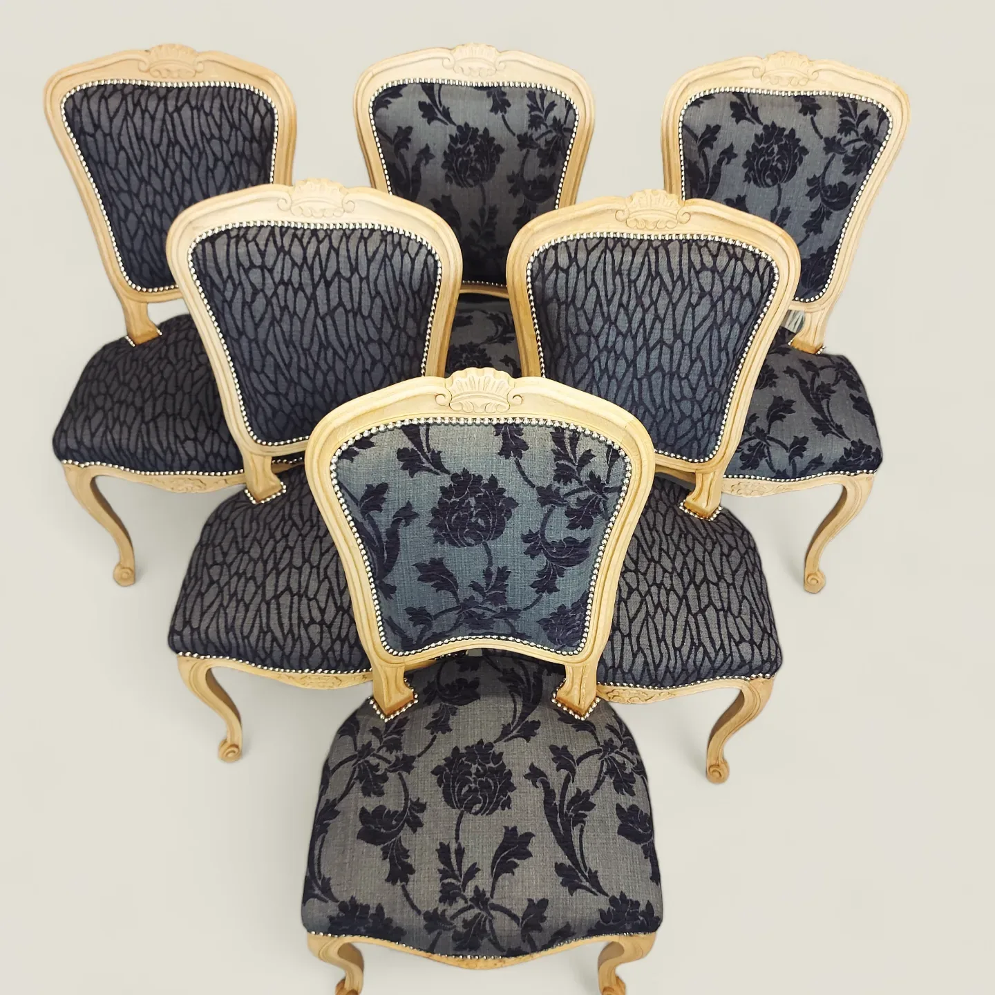 Six chaises Louis XV cérusées retapissées en tissu noir et gris à fleurs, finition cloutée